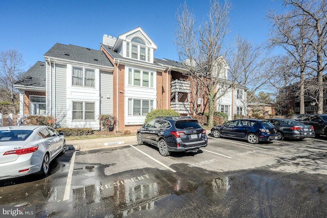 view of front of property featuring uncovered parking and brick siding