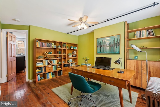 home office with dark wood-type flooring and ceiling fan