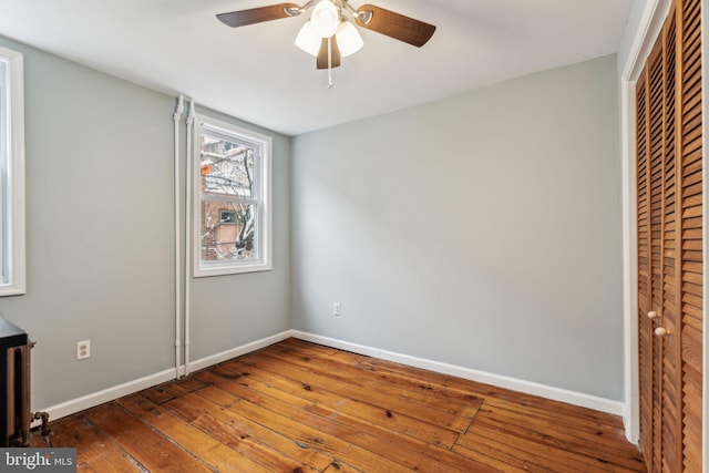 unfurnished bedroom with hardwood / wood-style flooring, ceiling fan, and a closet