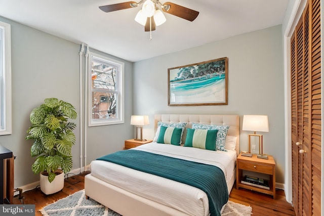 bedroom featuring wood-type flooring, ceiling fan, and a closet