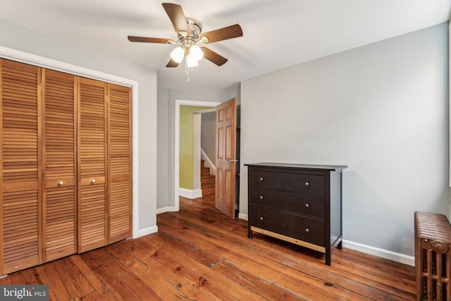 unfurnished bedroom with hardwood / wood-style flooring, ceiling fan, and a closet