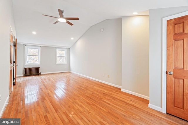 interior space featuring ceiling fan, lofted ceiling, radiator, and light wood-type flooring