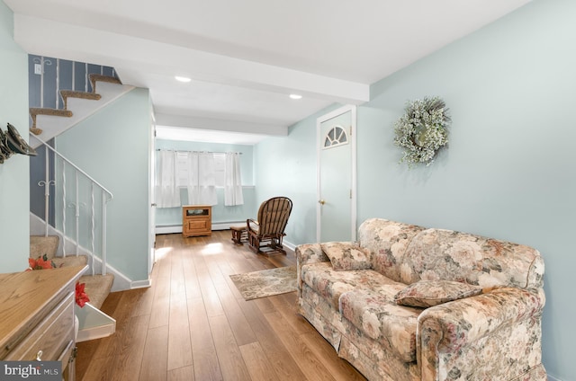 living area featuring hardwood / wood-style flooring, beam ceiling, and a baseboard heating unit