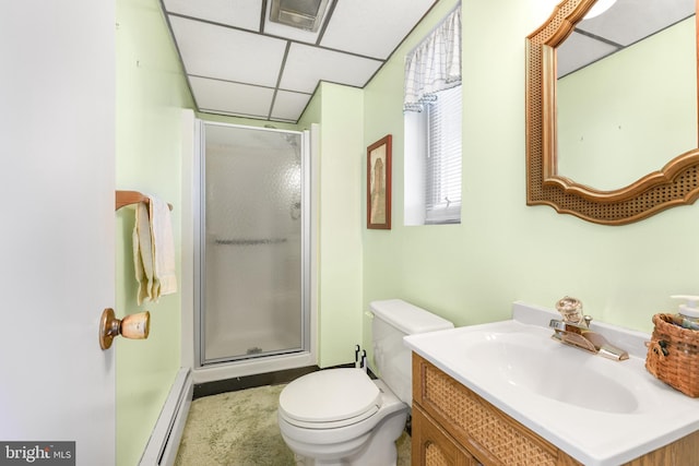 bathroom with toilet, a baseboard radiator, a shower with shower door, a drop ceiling, and vanity