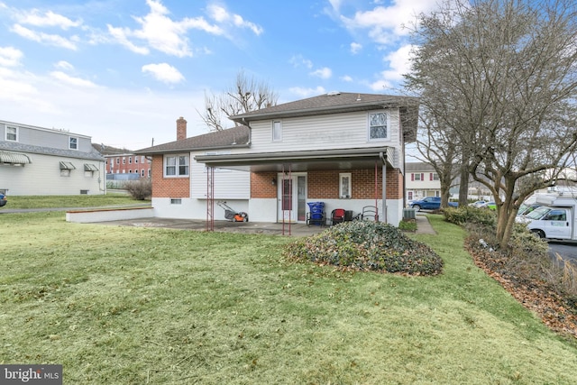 back of house with a patio and a lawn