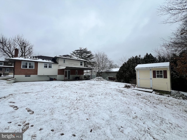 snow covered property featuring a shed