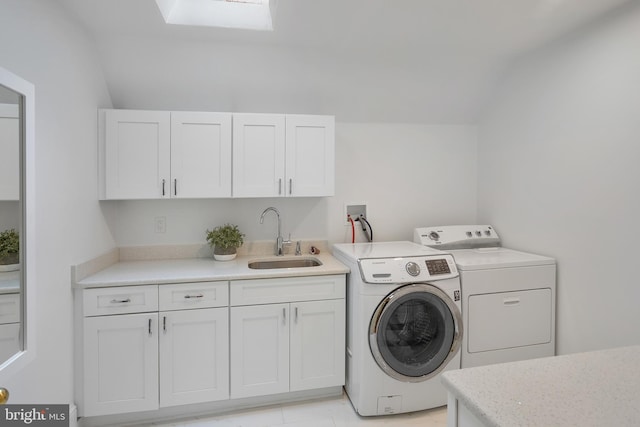 laundry room featuring cabinets, sink, washer and clothes dryer, and a skylight