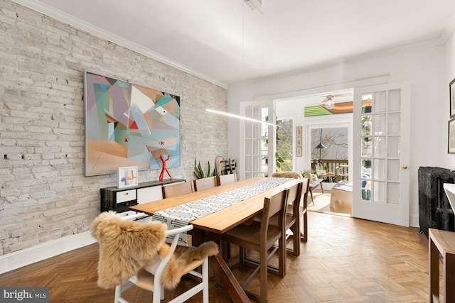 dining room featuring ornamental molding, french doors, baseboards, and brick wall