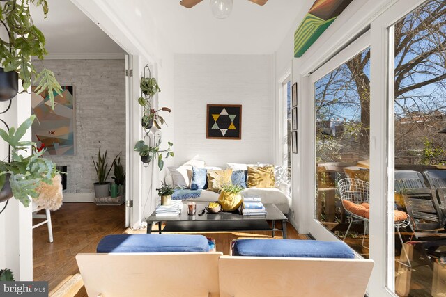 sunroom with a fireplace and a ceiling fan