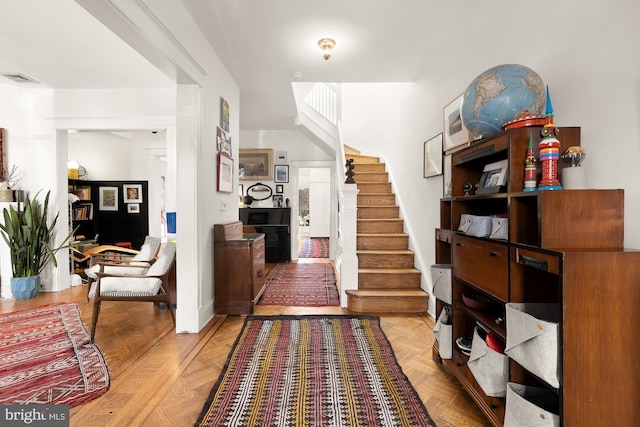 foyer entrance featuring stairs and visible vents