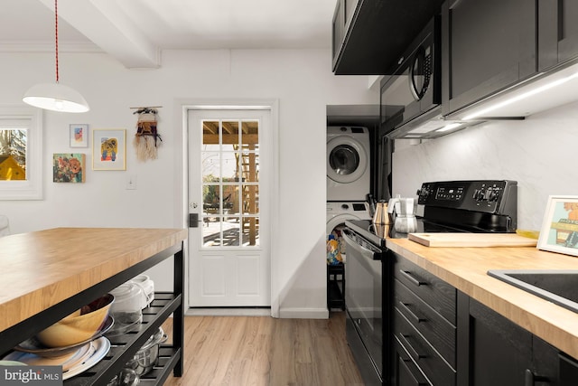 kitchen with decorative light fixtures, wood counters, black appliances, and dark cabinetry