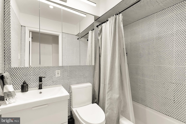 bathroom with tile walls, tasteful backsplash, toilet, shower / bath combo with shower curtain, and vanity