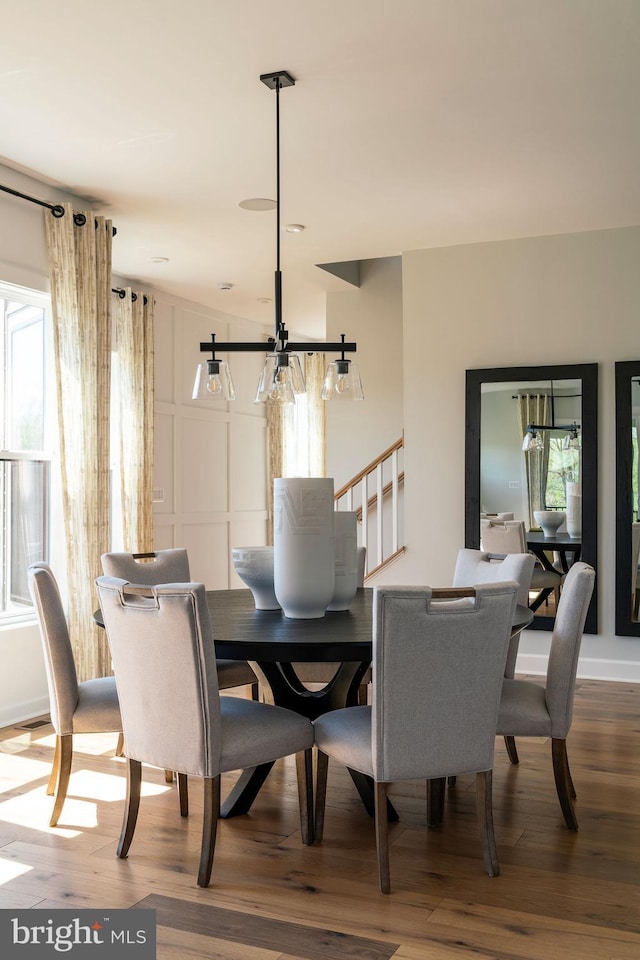 dining space featuring hardwood / wood-style flooring and an inviting chandelier