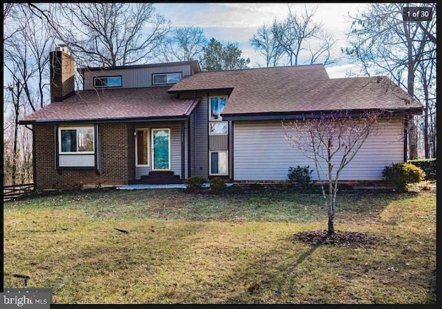 view of front facade featuring a shingled roof, a chimney, a front lawn, and brick siding