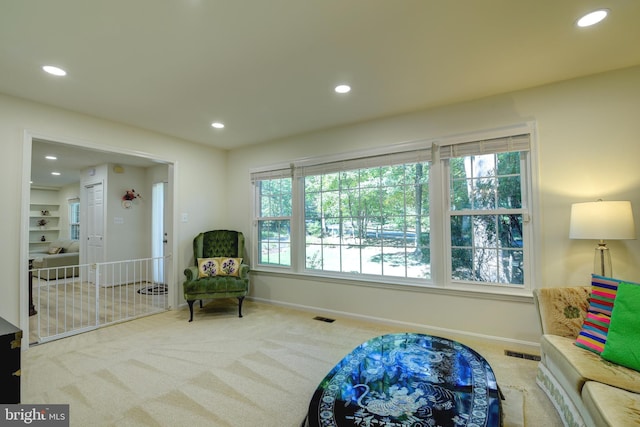 living area featuring a healthy amount of sunlight and light colored carpet