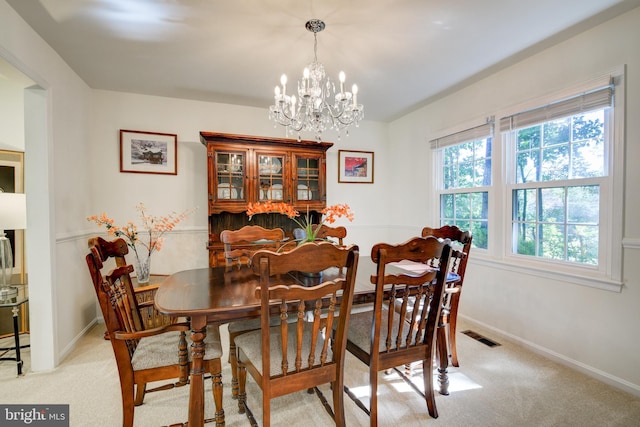 dining area with light carpet and a notable chandelier