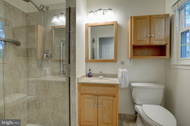 bathroom featuring vanity, toilet, and an enclosed shower