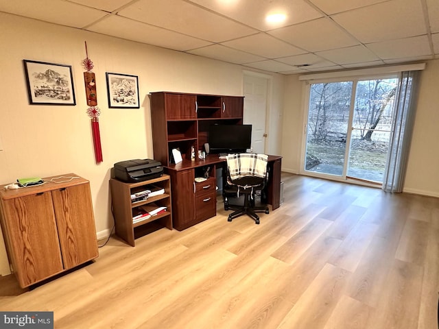 office featuring a paneled ceiling and light wood-type flooring