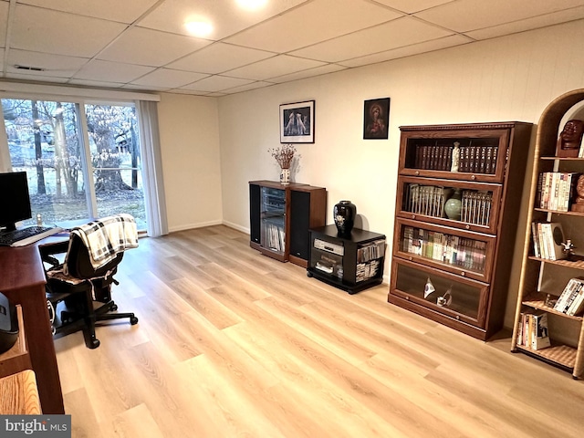 home office with a paneled ceiling and light wood-type flooring