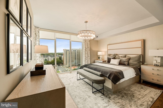 bedroom with expansive windows, a notable chandelier, access to outside, and light wood-type flooring