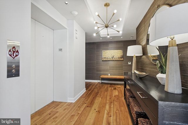 hallway featuring a chandelier and light hardwood / wood-style floors