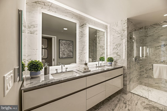 bathroom with vanity, a shower with door, and tile walls