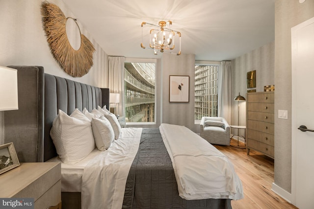 bedroom with an inviting chandelier and light hardwood / wood-style flooring