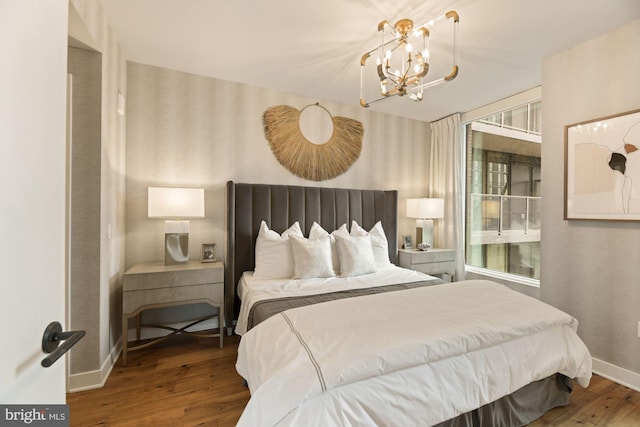 bedroom with wood-type flooring and a chandelier