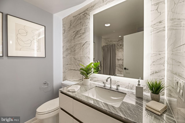 bathroom with vanity, toilet, tile walls, and walk in shower