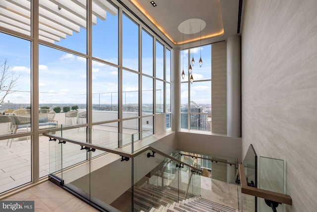 staircase with a wall of windows, plenty of natural light, and a high ceiling