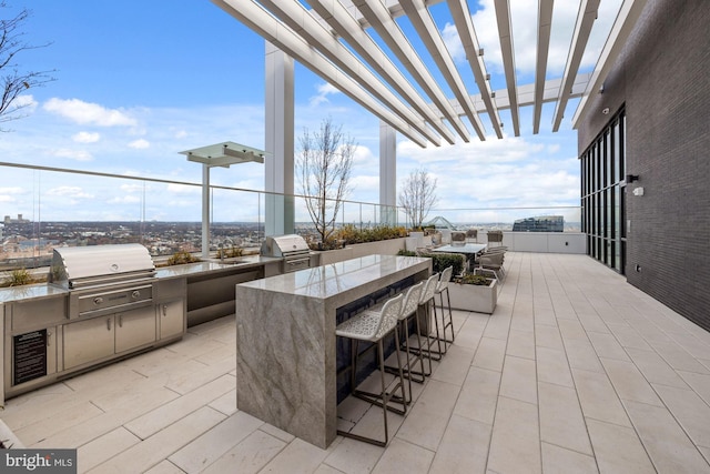 view of patio featuring a grill, an outdoor kitchen, a wet bar, and a pergola