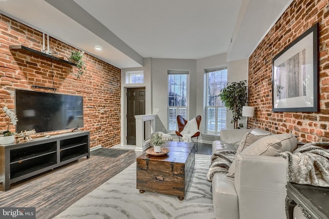 living room featuring hardwood / wood-style flooring and brick wall