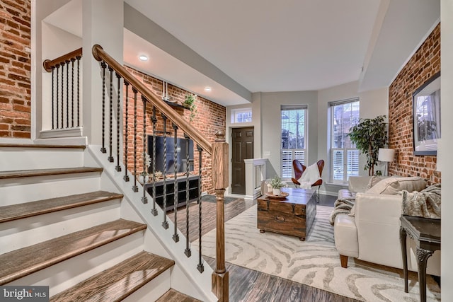 living room with hardwood / wood-style flooring and brick wall