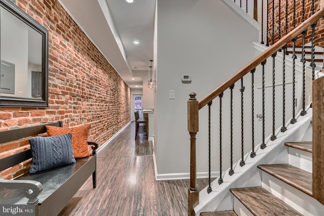 interior space with dark hardwood / wood-style flooring and brick wall