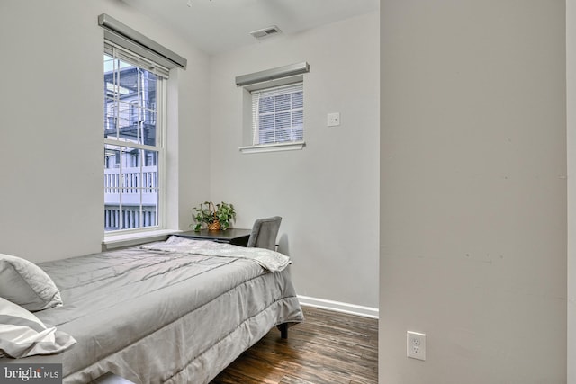 bedroom with dark hardwood / wood-style flooring