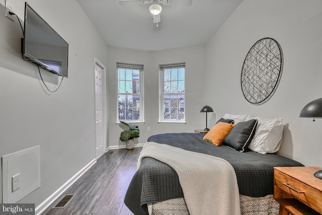 bedroom with dark hardwood / wood-style flooring and ceiling fan