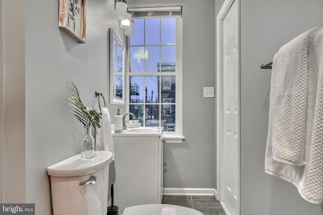 bathroom with a healthy amount of sunlight, sink, and toilet