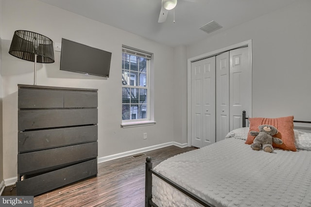 bedroom with a closet, dark hardwood / wood-style floors, and ceiling fan