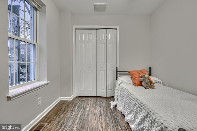 bedroom featuring dark wood-type flooring and a closet