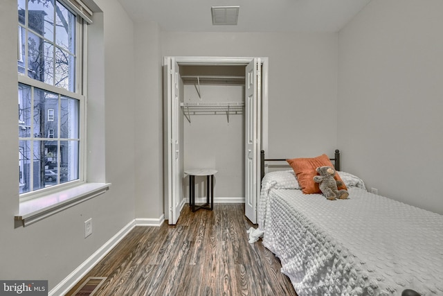 bedroom with dark hardwood / wood-style flooring and a closet