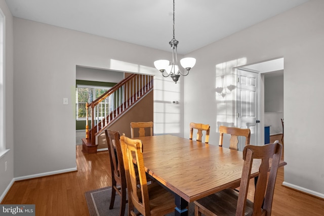 dining room featuring an inviting chandelier, baseboards, and wood finished floors