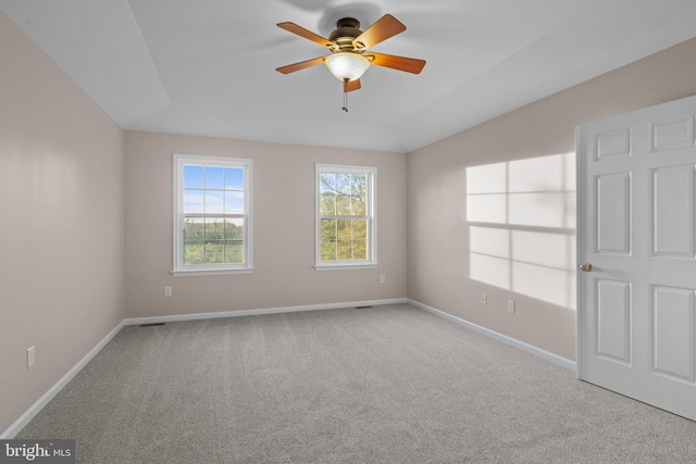 empty room featuring carpet floors, a ceiling fan, baseboards, and vaulted ceiling