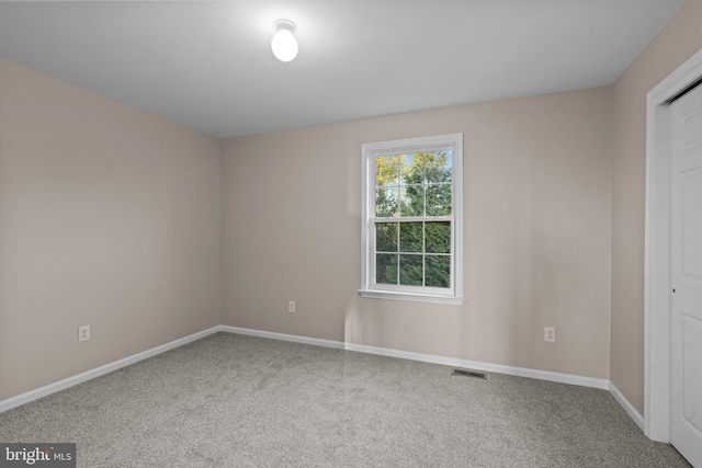 empty room featuring baseboards, carpet flooring, and visible vents