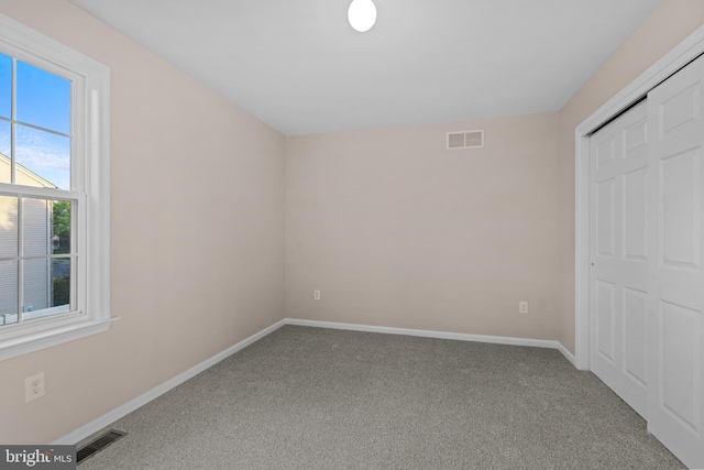 unfurnished bedroom featuring carpet floors, baseboards, and visible vents