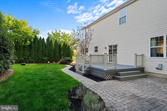 back of house featuring a yard, a patio, and a wooden deck