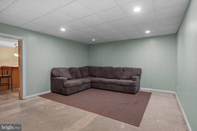 living area featuring baseboards, recessed lighting, and a paneled ceiling