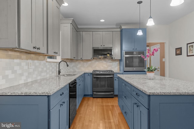 kitchen featuring light wood-style floors, a sink, blue cabinets, and stainless steel appliances