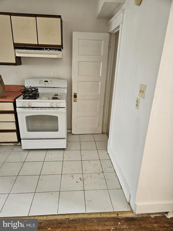 kitchen featuring white cabinetry, white gas stove, and light tile patterned floors