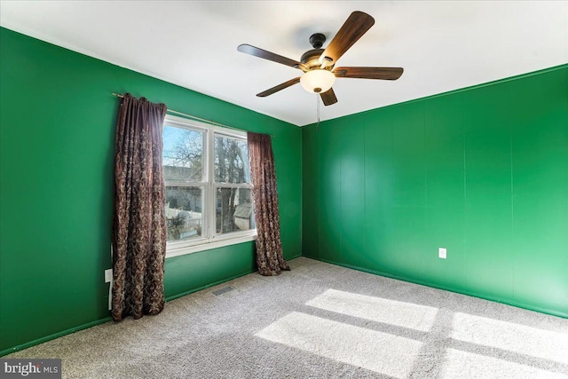 carpeted spare room with ceiling fan