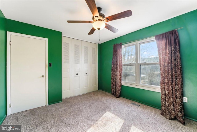 unfurnished bedroom with a closet, ceiling fan, and carpet floors